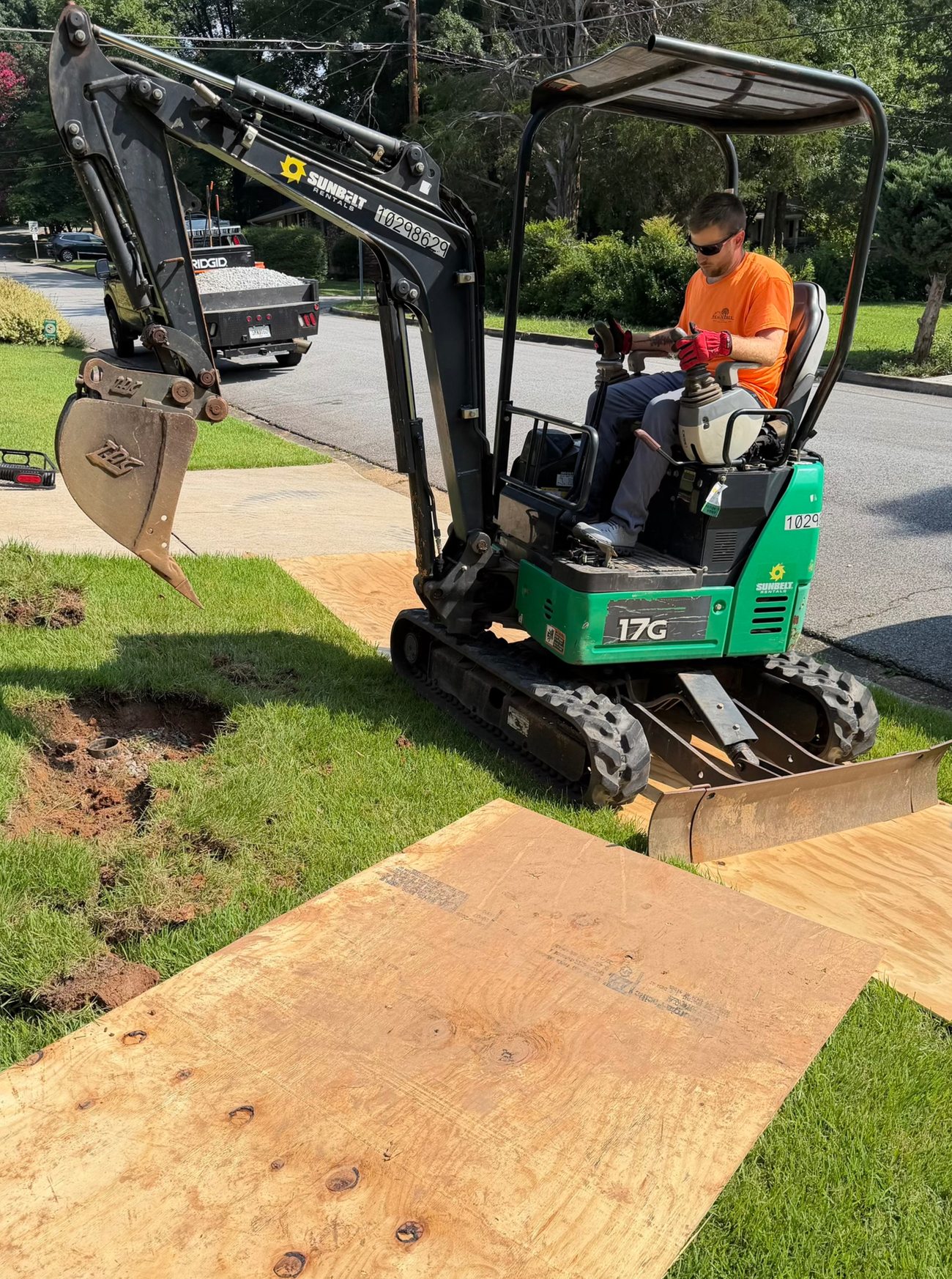 Peachtree team member operating a compact excavator during drainage work